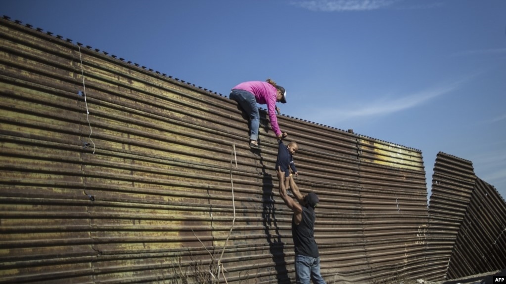 一家中美洲人试图越过美墨边界在加州地段的边界墙